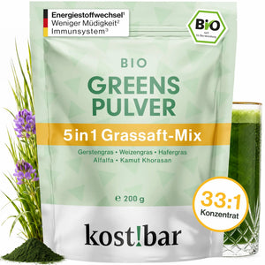 kost!bar BIO Greens Pulver Beutel 200 g neben einem Glas grünem Grassaft – Bio Gerstengras Grassaftpulver aus 5 Gräsern